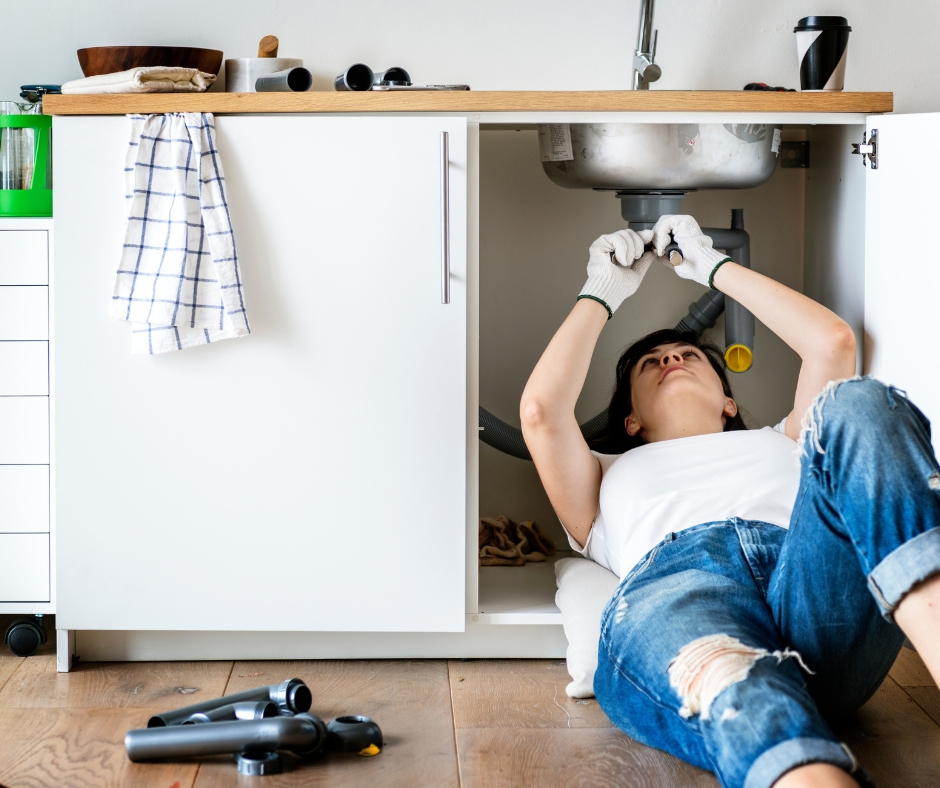 Woman fixing kitchen sink